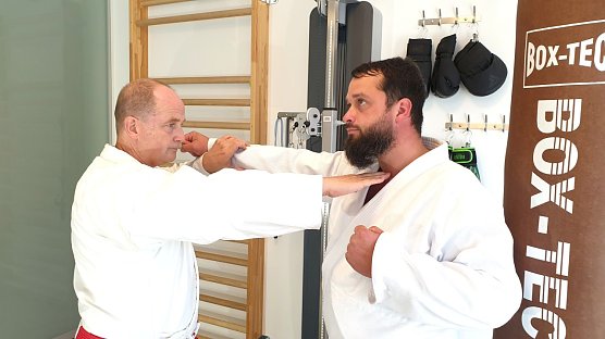 Foto: l. n. r.: Joachim Retzek und Markus Retzek. Fingerstich (Nukite) zum Kehlkopf = eine Atemitechnik (Sto&szlig;/Schlag) aus dem Karate und die auch innerhalb der Selbstverteidigung im h&ouml;heren Kyu-Bereich (h&ouml;here Sch&uuml;lergruppe) trainiert wird. (Foto: Joachim Retzek)