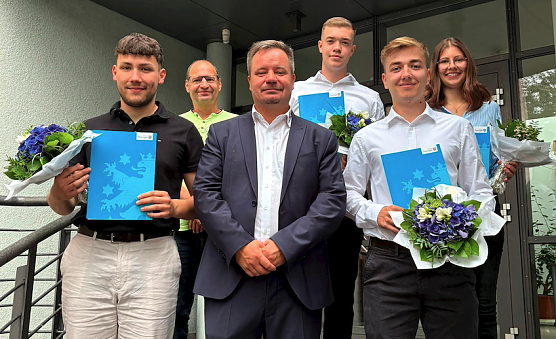 Niclas B&ouml;hning, Marius Kromer, Simon Egert und Sarah Apostel (v.l.n.r.) mit ihren Abschlusszeugnissen. Gratulationen gab es von B&uuml;rgermeister Christian Zwingmann (Mitte) und Personalrat Kamillo Schwanengel (hinten links).  (Foto: Luisa Hellrung)
