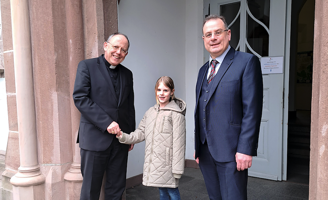 Bischof Ulrich Neymeyr (l.) und Direktor Heinz-Peter Kaes (r.), Schulleiter des Gymnasiums Bergschule St. Elisabeth, begr&uuml;&szlig;en die Sch&uuml;lerin Lena Schwarz (Mitte) in der Anmeldewoche f&uuml;r die neue Regelschule (Foto: Bisch&ouml;fliches Ordinariat)