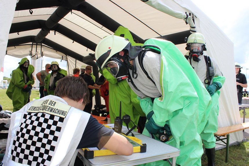 Gefahrgutzug &uuml;bte: Mit Chemikalienschutzanz&uuml;gen ausger&uuml;stete Kameraden werden registriert